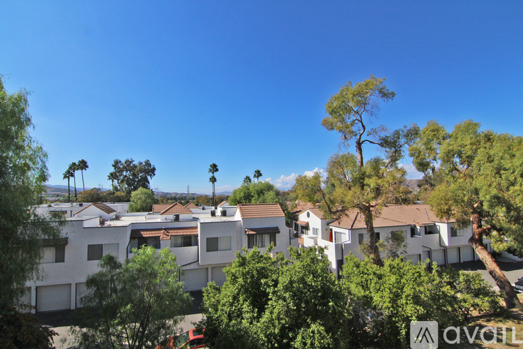 A row of houses with trees in front.