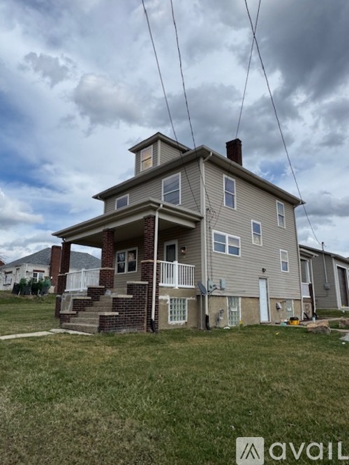 A two-story house with a balcony and a front porch.