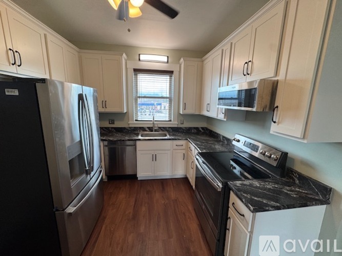 A kitchen with a black stove top oven and a black refrigerator.