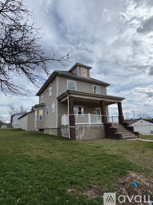A two-story house with a grey exterior and a white porch.
