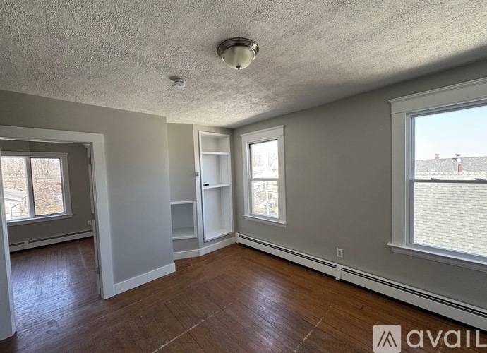 A room with a window and a door is available for rent.
