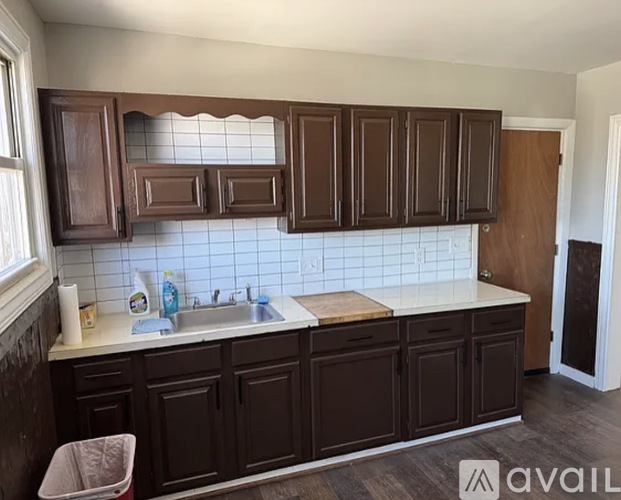 A kitchen with brown cabinets and a white sink.
