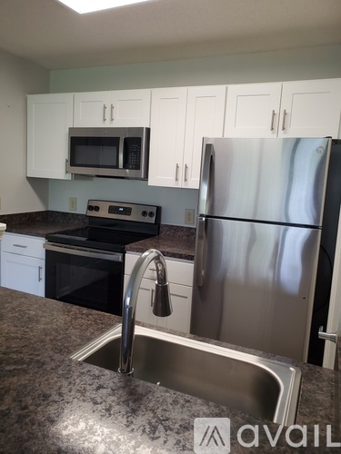 A kitchen with a stainless steel refrigerator and a sink.