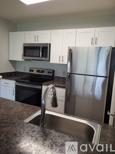 A kitchen with a stainless steel refrigerator and a sink.