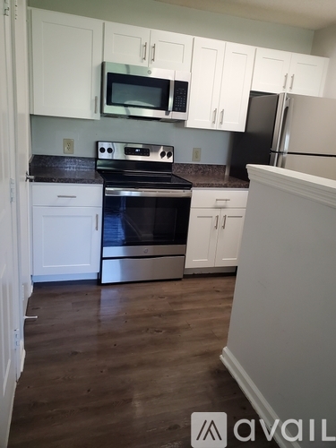 A kitchen with white cabinets and a black stove top.