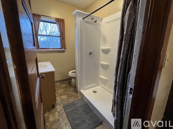 A bathroom with a toilet, sink, and shower.