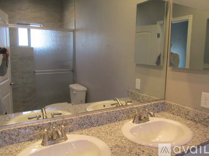 A bathroom with two sinks and a large mirror.
