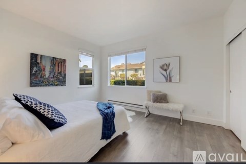 A bedroom with a large bed and a bench seat.