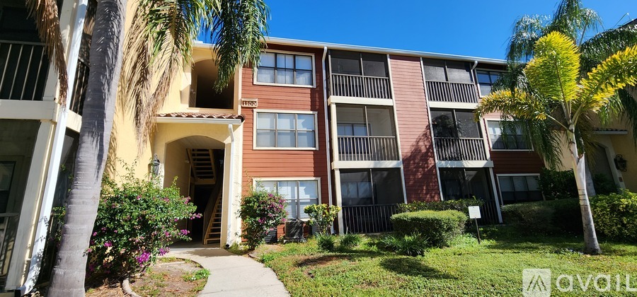 A sunny day at a multi-story apartment building with a clear blue sky.