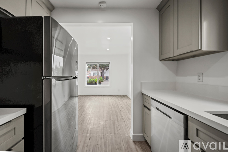 A modern kitchen with a black refrigerator and white countertops.