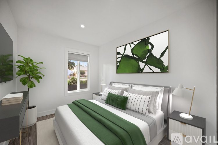 A bedroom with a large bed and a green plant.