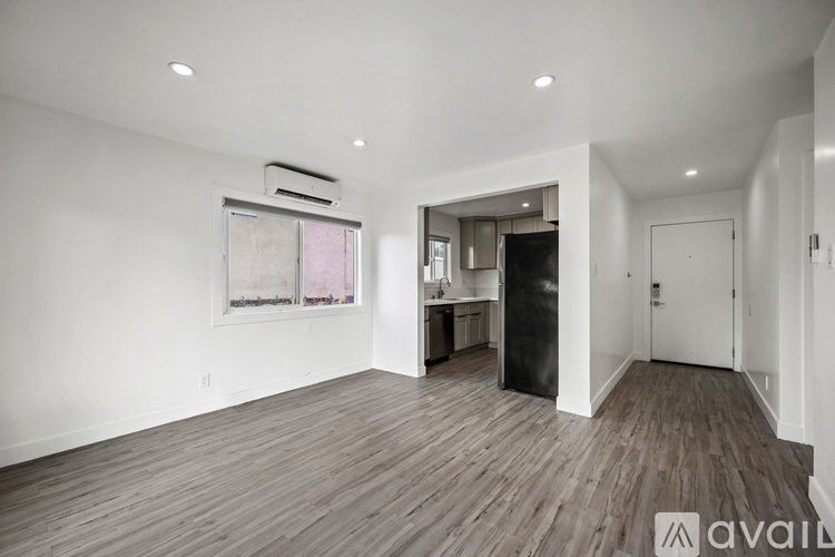 A spacious room with wooden flooring and a large painting on the wall.