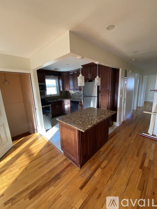A kitchen with wooden floors and a granite countertop.