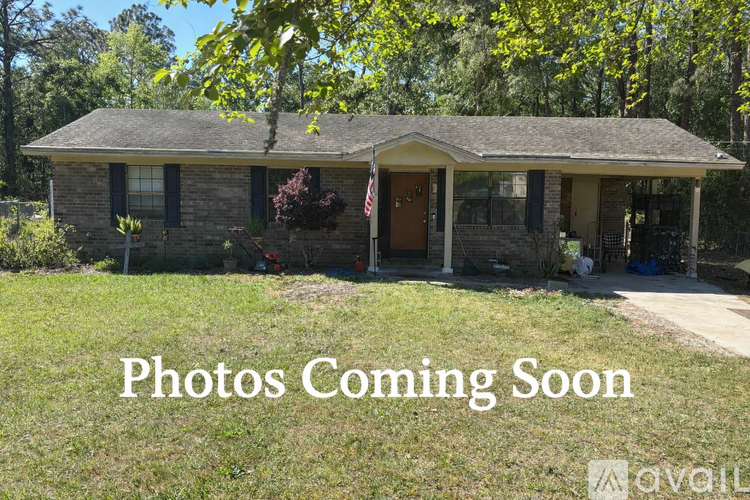 A house with a brown door and a sign that says "Photos Coming Soon".
