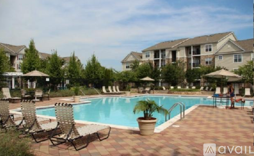 A pool surrounded by chairs and umbrellas in a residential area.