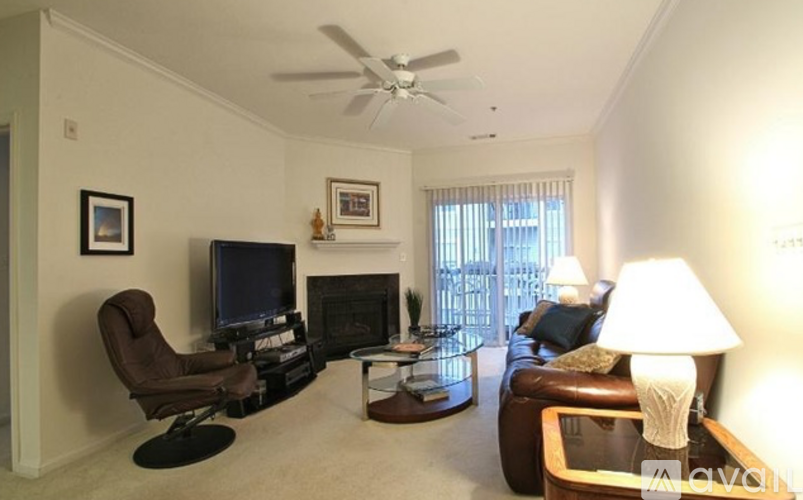 A living room with a brown leather chair and a fireplace.