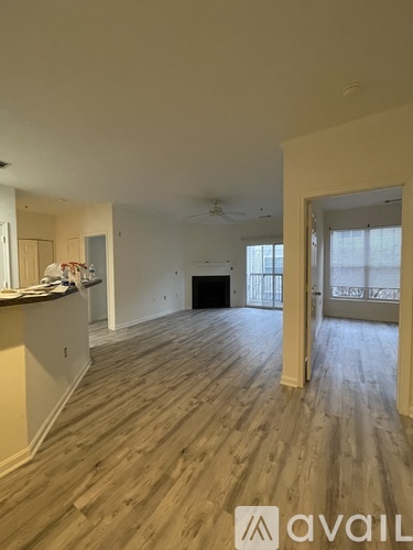 A spacious room with wooden flooring and a ceiling fan.