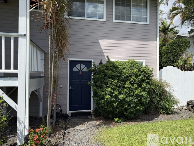 A house with a blue door and a small garden in front.