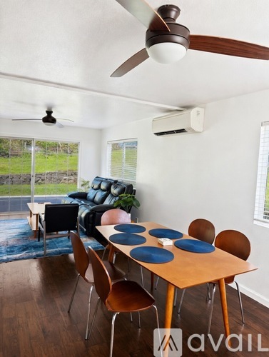 A dining room with a table set for six and a fan on the ceiling.