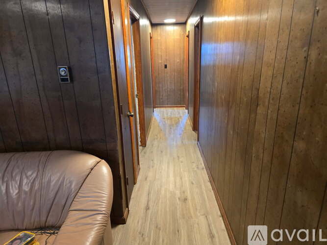 A long hallway with wooden floors and doors on both sides.