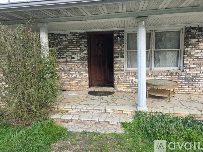 A house with a brown door and a bench outside.