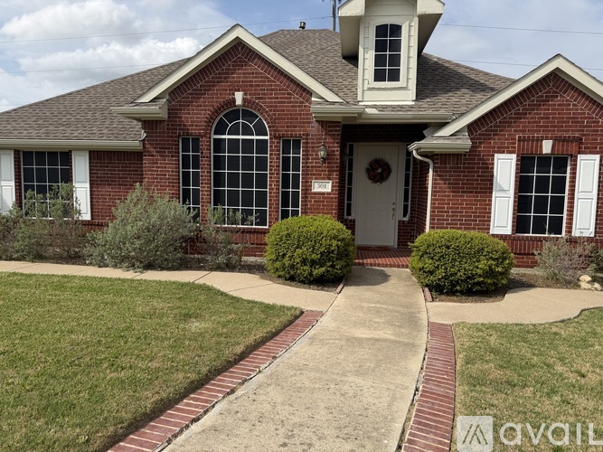 A brick house with a white door and windows.