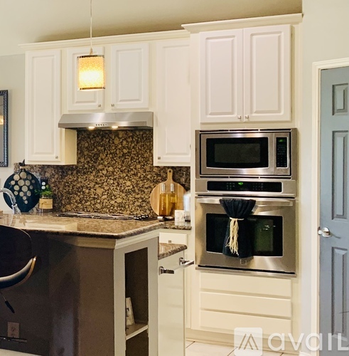 A kitchen with a patterned backsplash and a stainless steel oven.