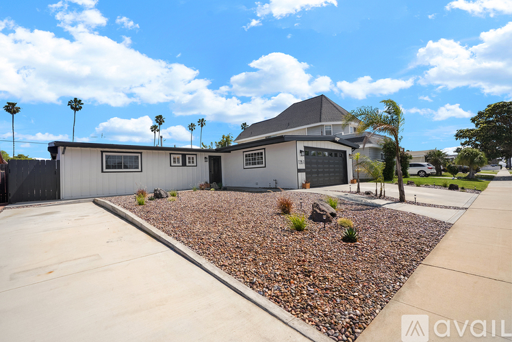 A house with a driveway and landscaping in front.