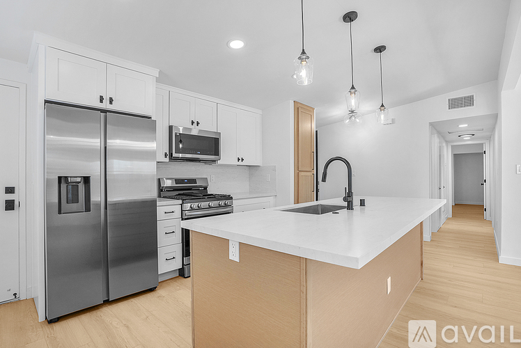 A modern kitchen with wooden cabinets and stainless steel appliances.