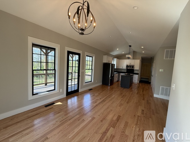 A spacious room with wooden floors and a kitchen area.