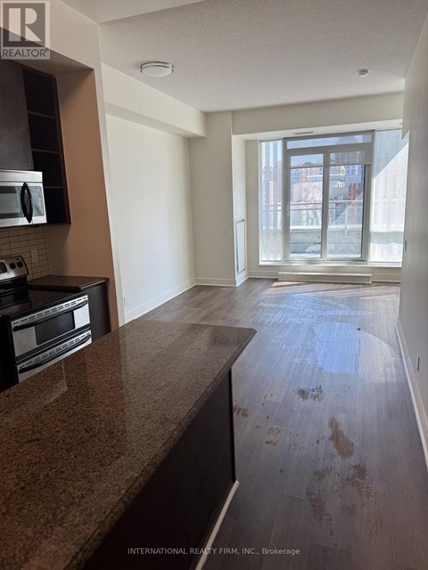 A kitchen with a granite counter top and a window.