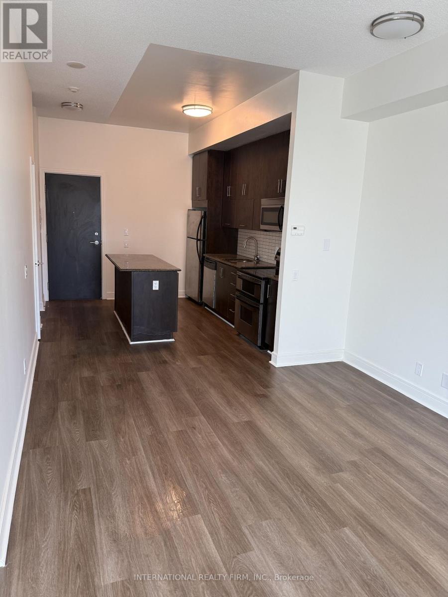 A room with wooden flooring and a black door.
