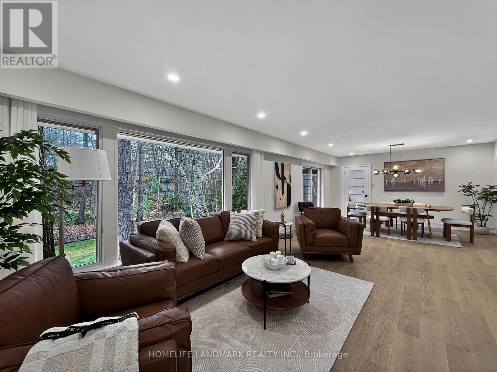 A well-lit living room with a brown leather sofa and a coffee table.