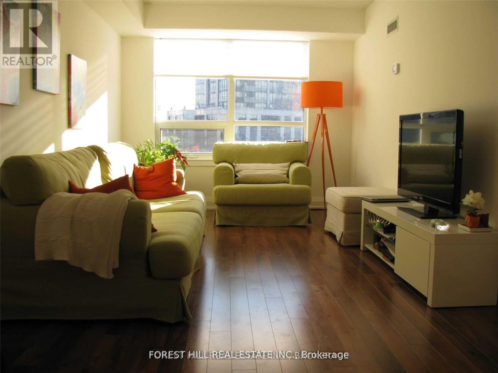 A living room with a couch, chair, and television.