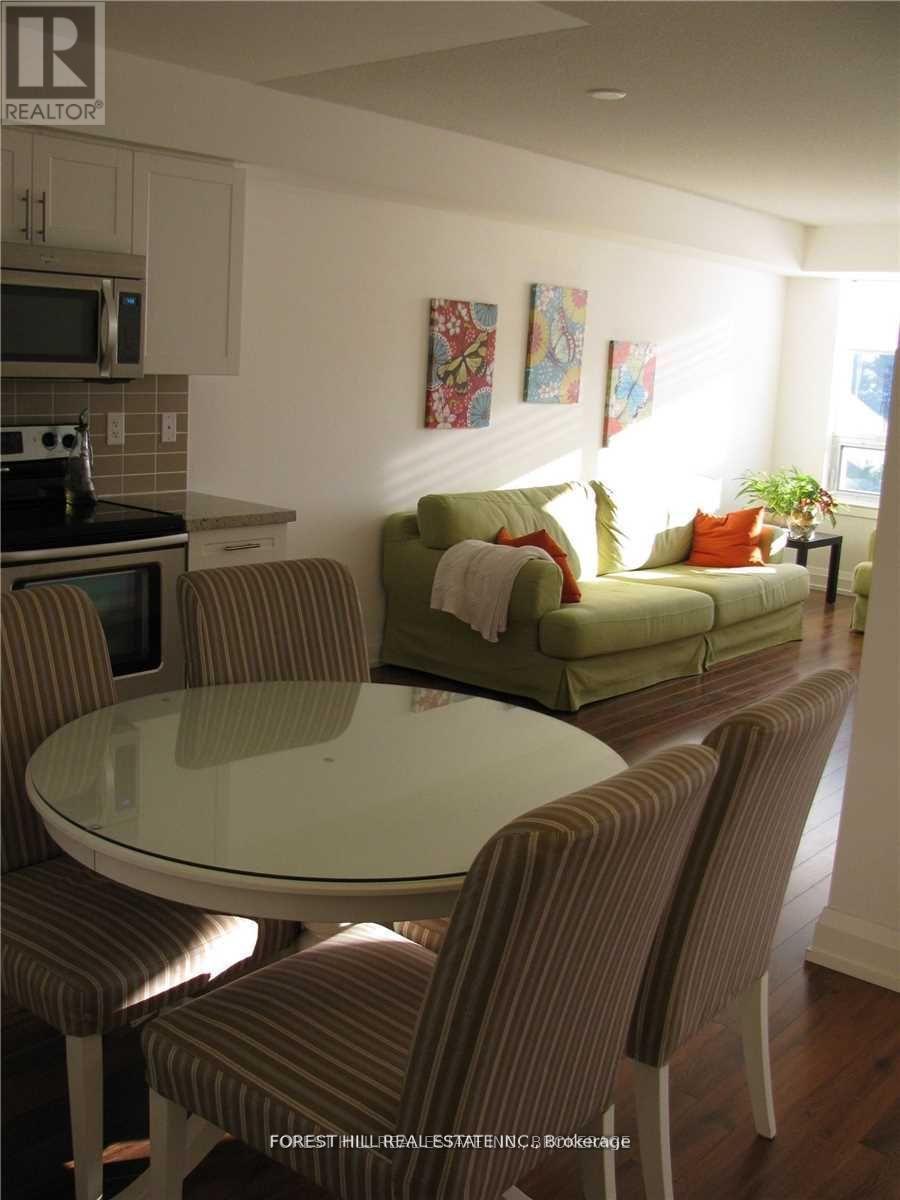 A modern dining room with a glass table and striped chairs.
