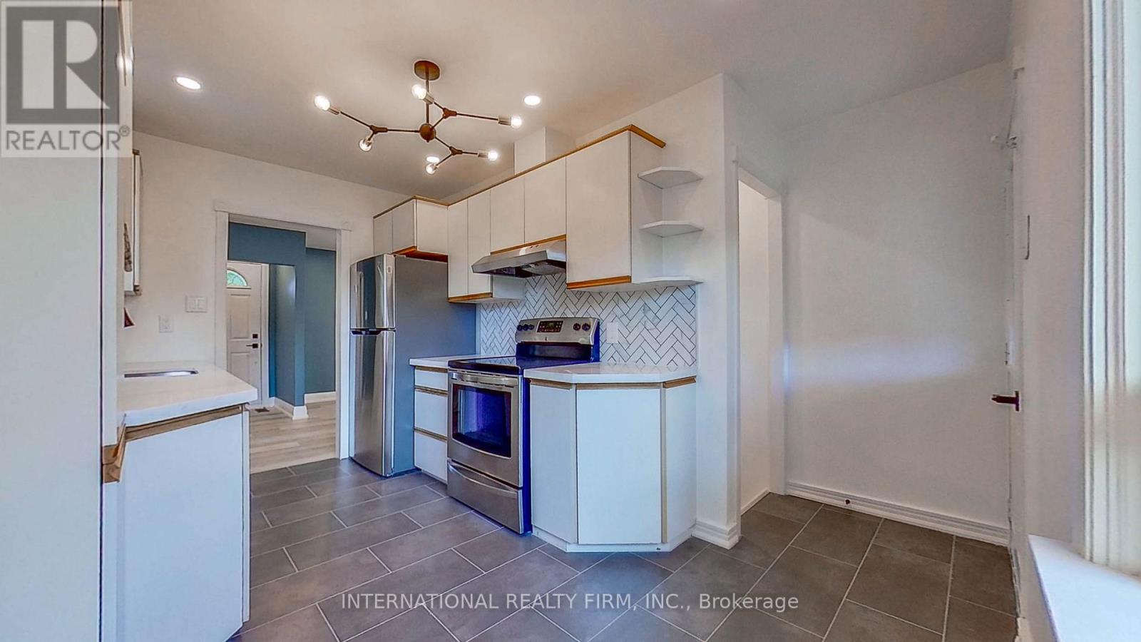 A kitchen with white cabinets and a tile floor.
