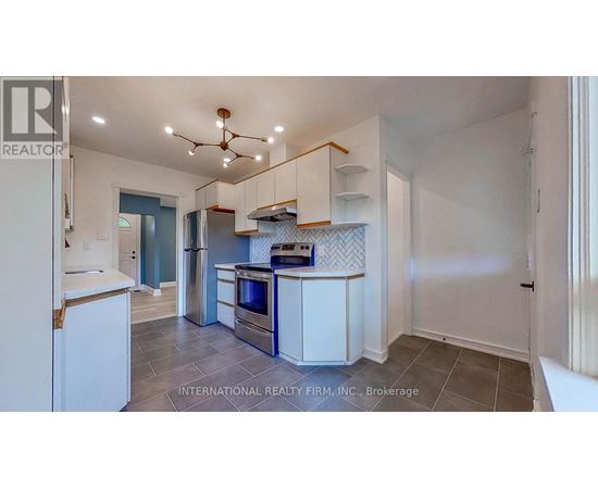 A kitchen with white cabinets and a tile floor.