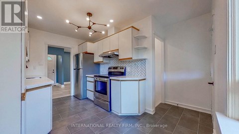 A kitchen with white cabinets and a tile floor.
