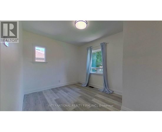 A room with a window and a view of trees outside.