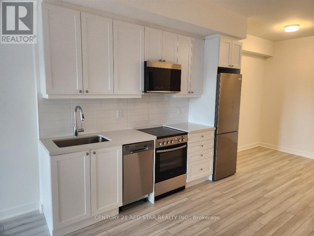 A kitchen with white cabinets and a stainless steel refrigerator.