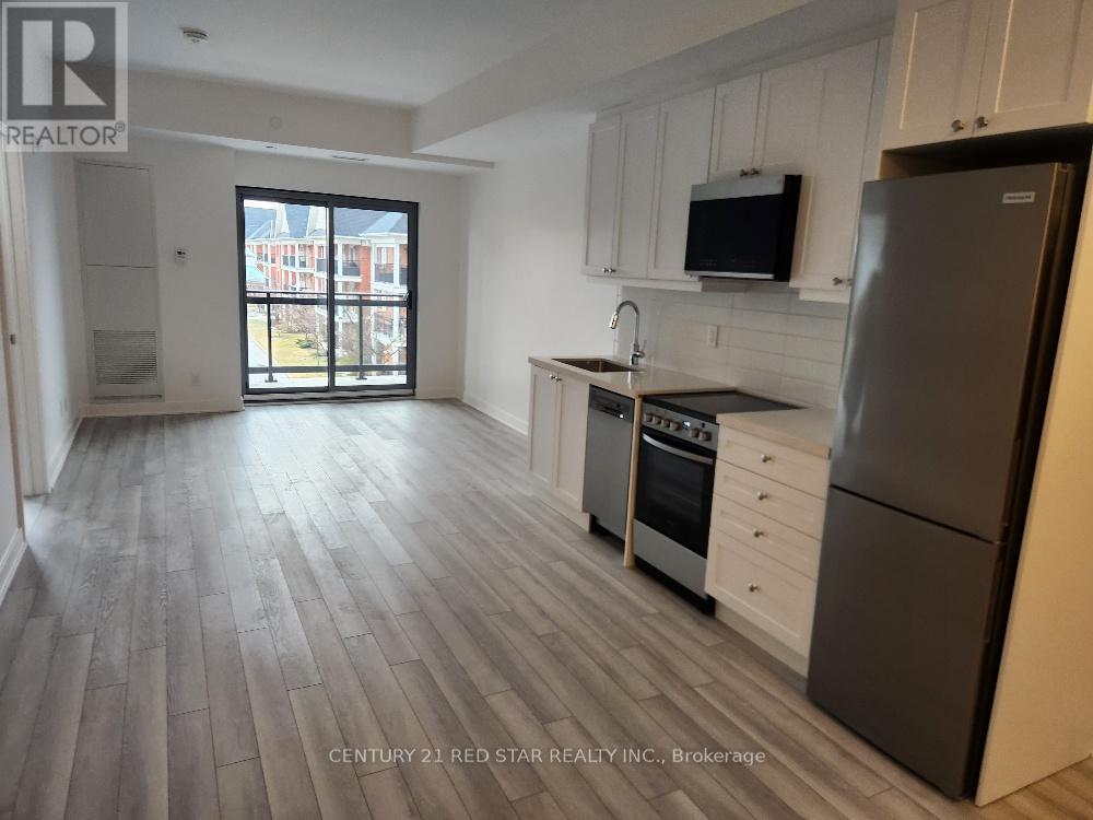 A kitchen with a refrigerator, microwave, and oven.