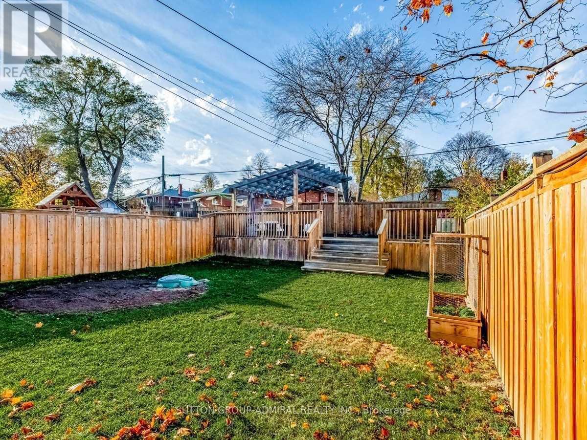 A backyard with a wooden fence and a small pool.