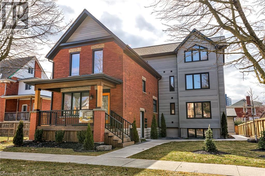 A two-story house with a red brick exterior and a grey exterior.