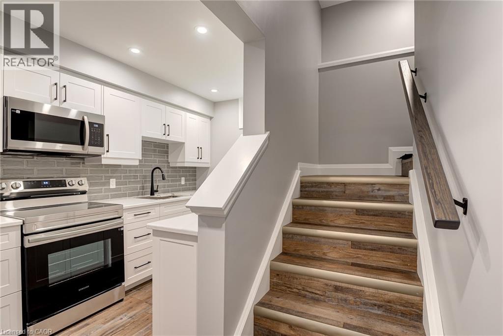 A modern kitchen with white cabinets and a stainless steel oven.