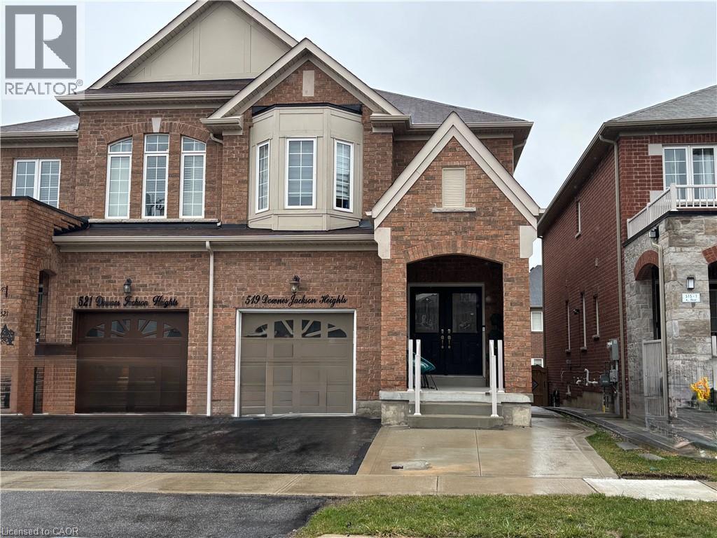 A large brick house with a garage door and a balcony.