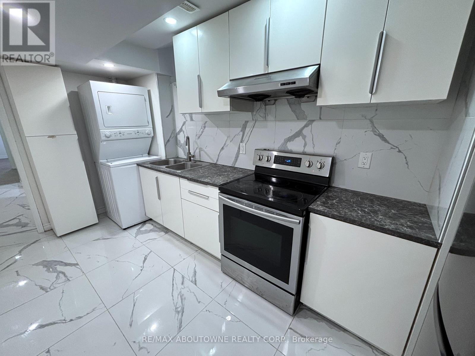 A kitchen with white cabinets and a black counter top.
