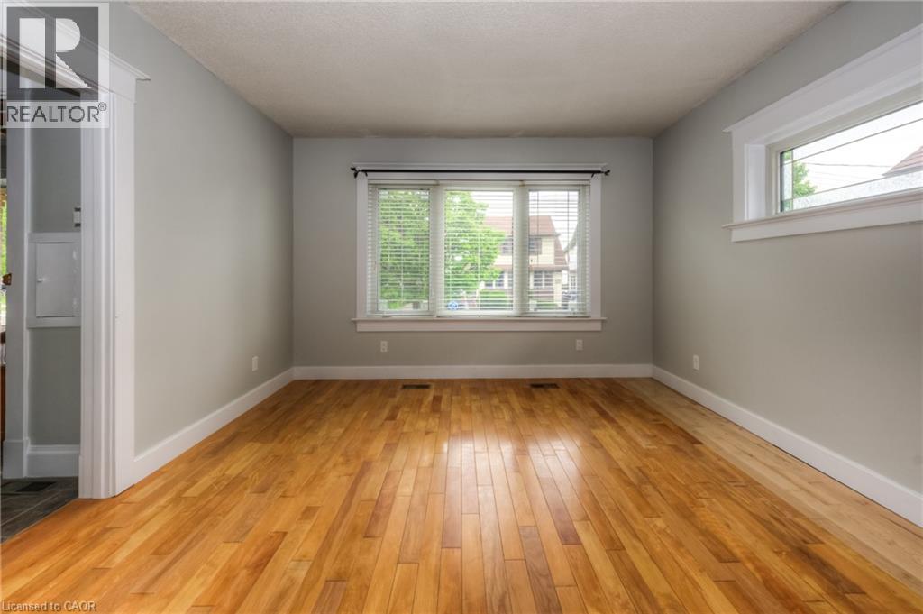 A room with wooden floors and a window with blinds.