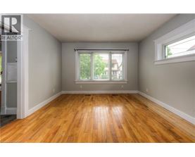 A room with wooden floors and a window with blinds.