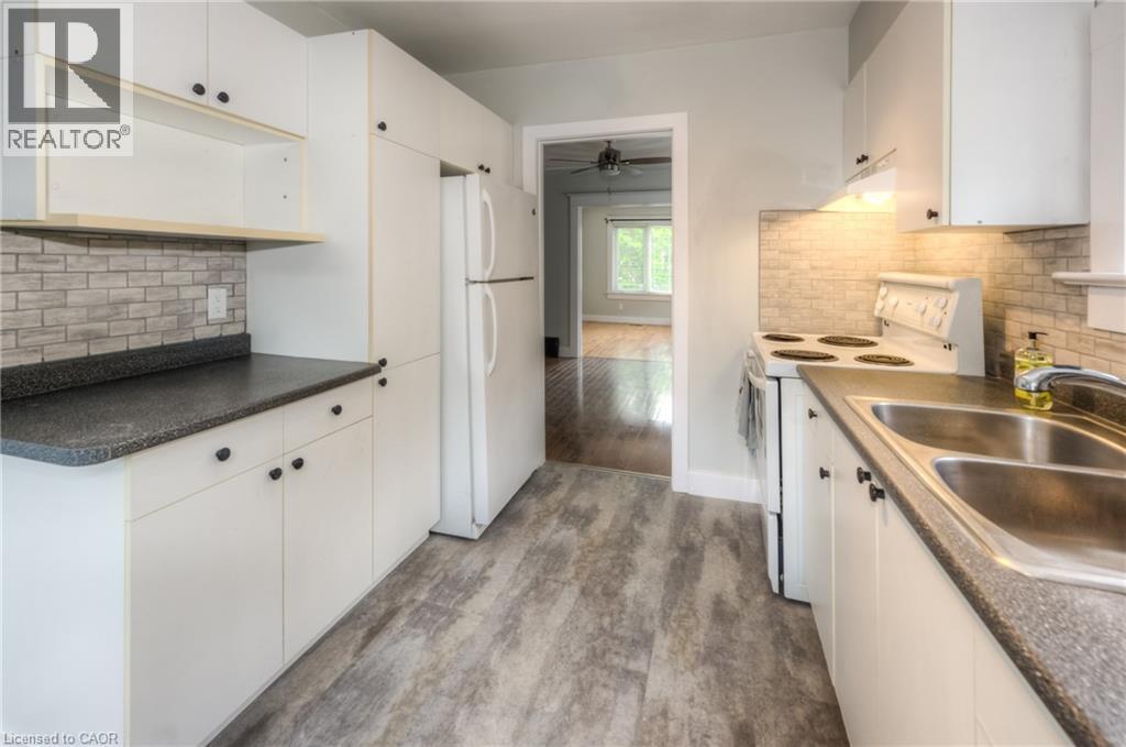 A kitchen with white cabinets and a brick backsplash.