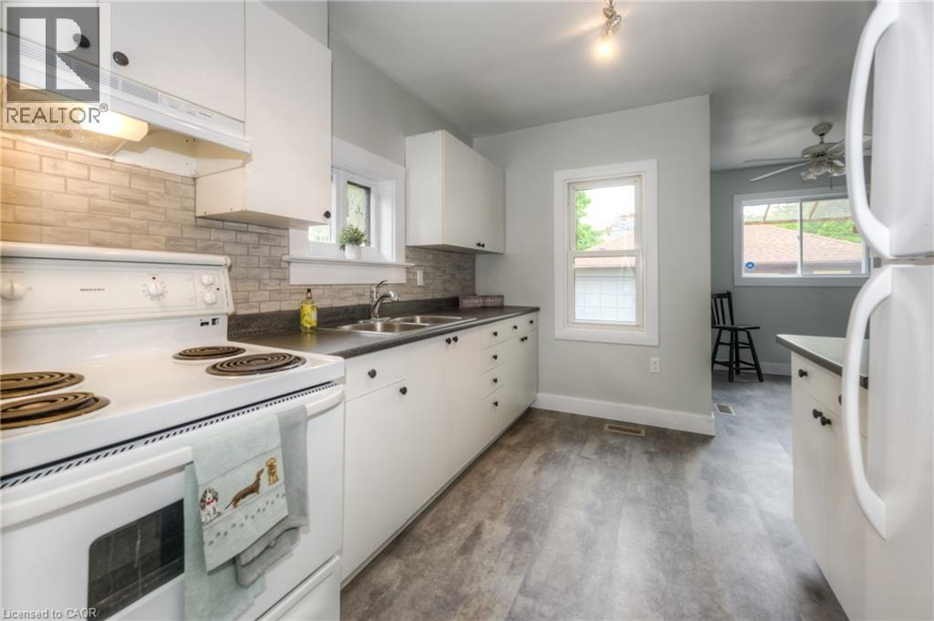 A kitchen with white cabinets and a white stove top oven.